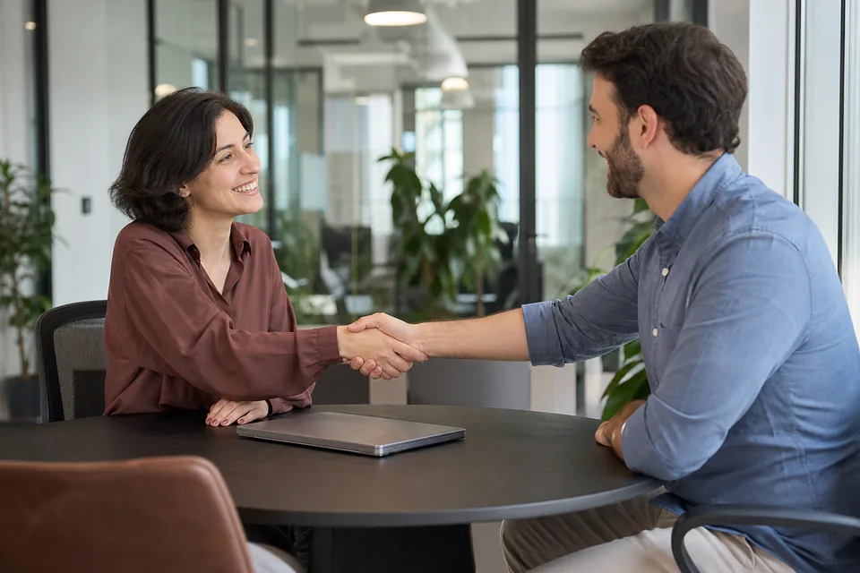 Two business partners shaking hands after agreeing to share confidential information